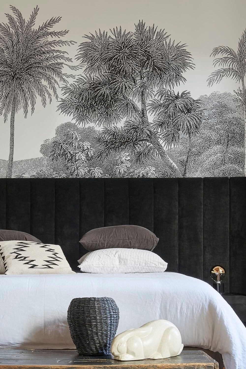 cama con cojines apilados y cabecero negro