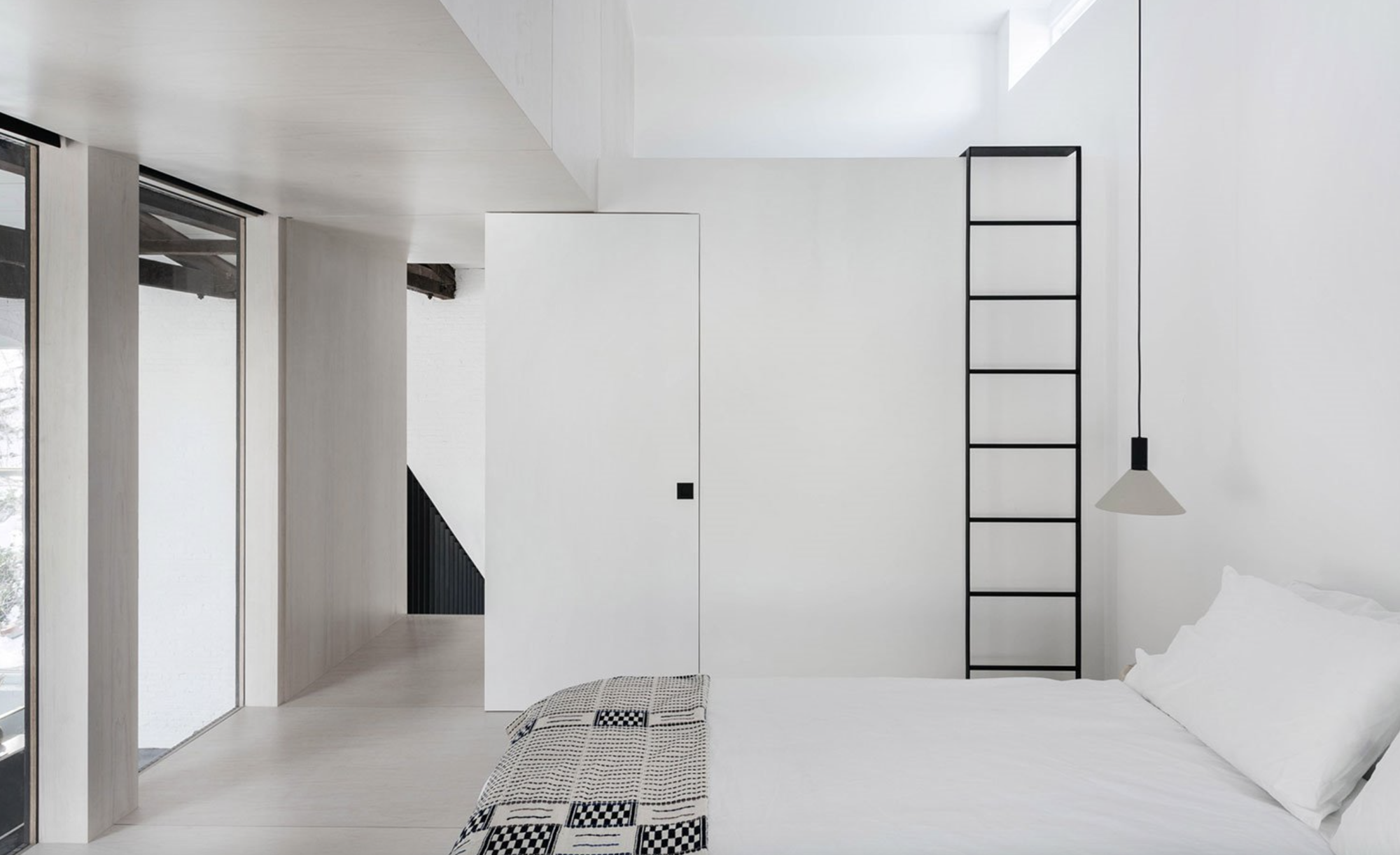 dormitorio en blanco y escalera negra