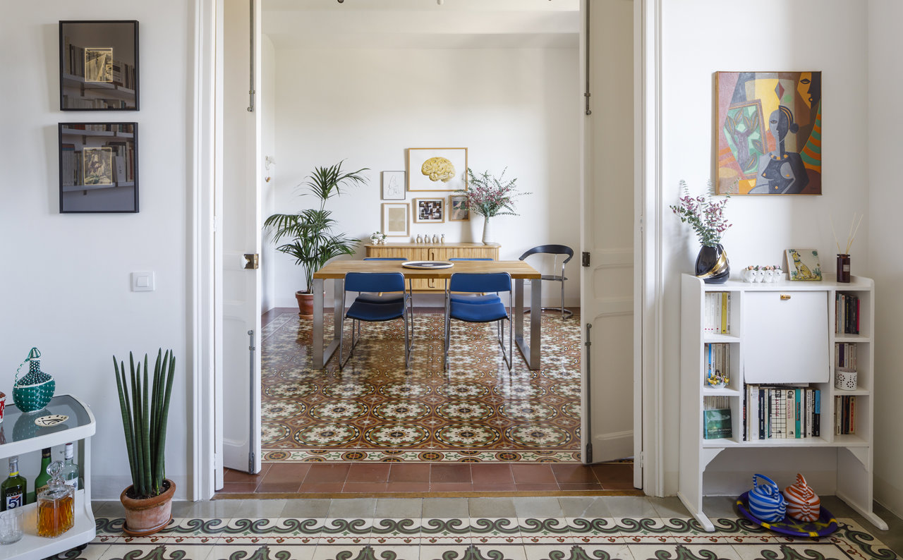 Comedor con puertas de color blanco y suelo hidraulico  de un piso en Barcelona