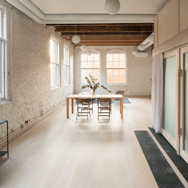 Consola negra, suelo de madera, lof inustrial, pared de obra vista, puertas de cristal esmerilado