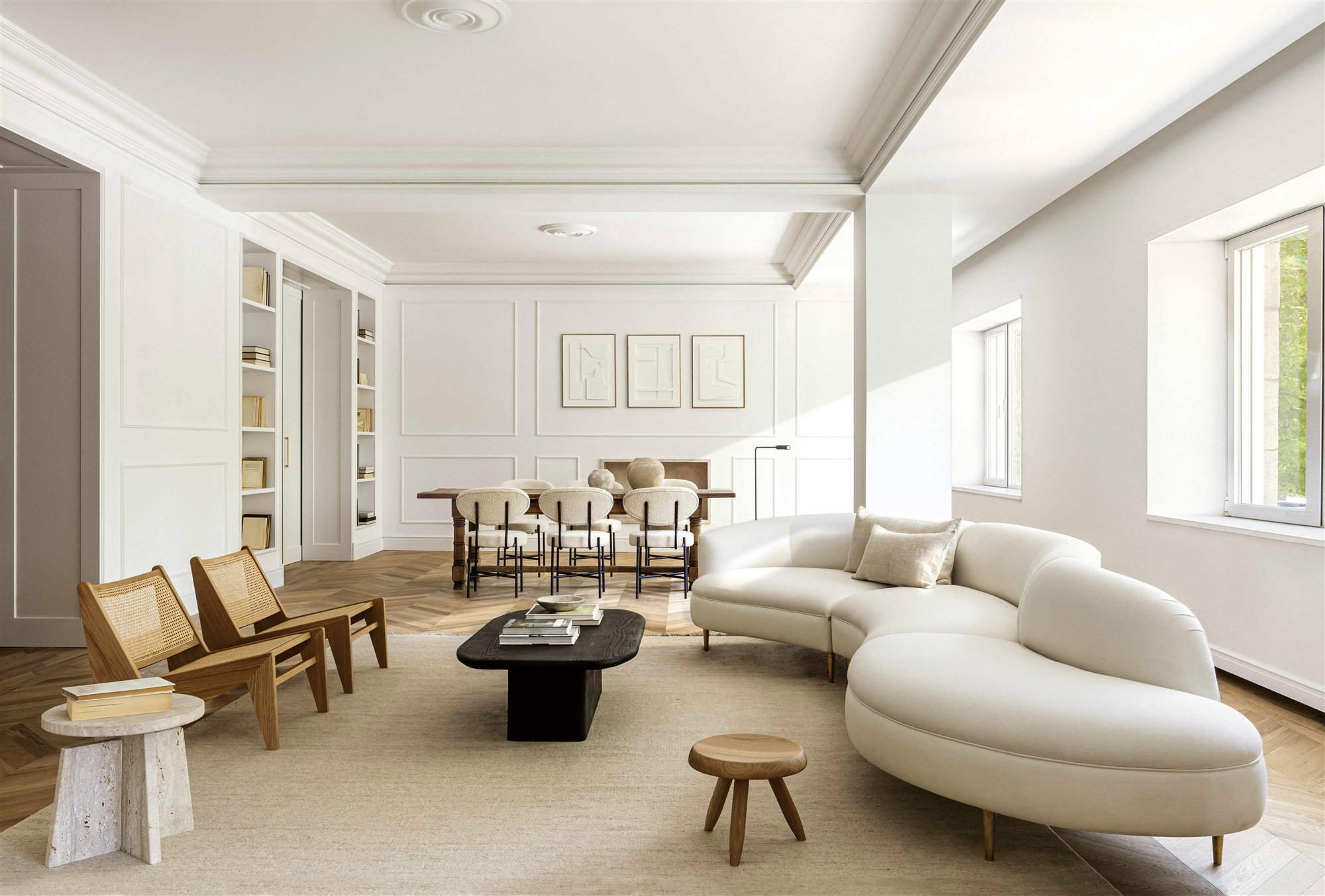 Salón decorado en blanco y madera con mucha luz natural.