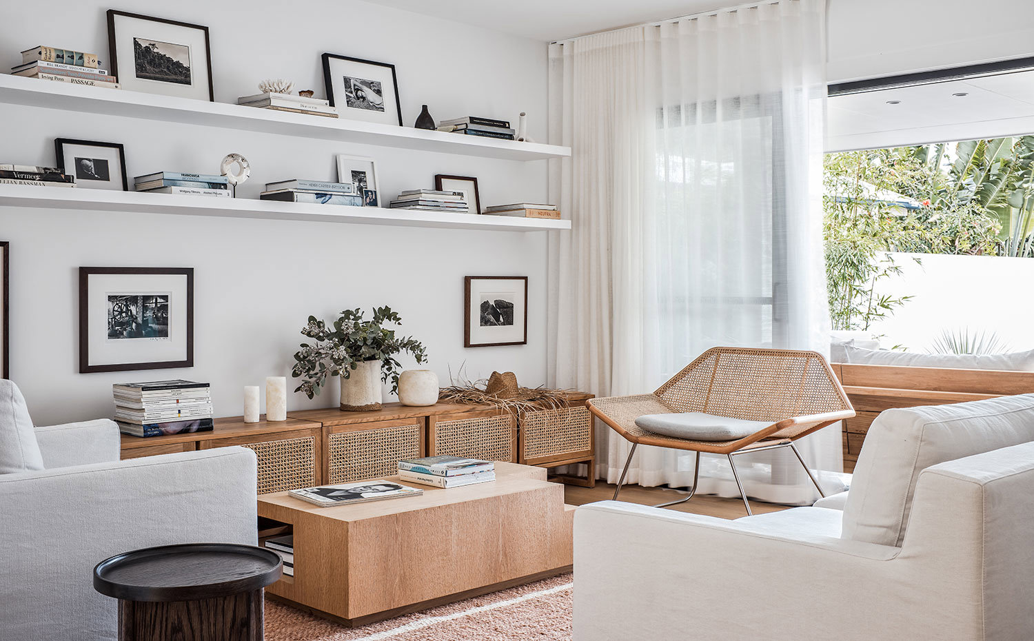 Salo´n con butaca de fibra trenzada, sofa´ y sillo´n gris claro, mesa y mueble bajo de madera y fibra